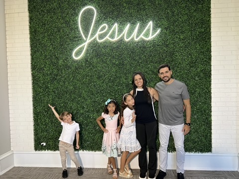Família diante do letreiro Jesus